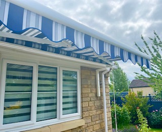 Blue striped awning fitted above a patio door