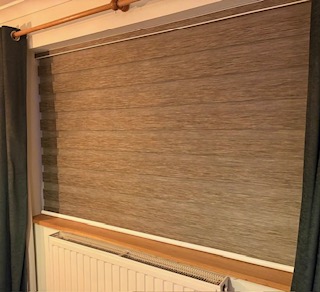 Closed brown vision roller blind in a bright white room