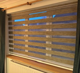 Open brown vision roller blind fitted in a white room