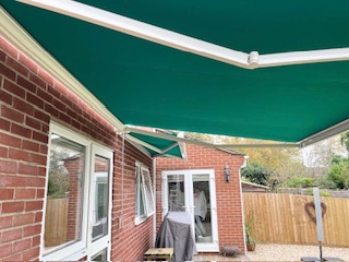 Solid green awning providing shade over a patio in Somerset