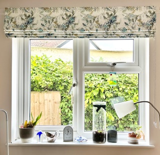 Patterned roman blind fitted above a kitchen window