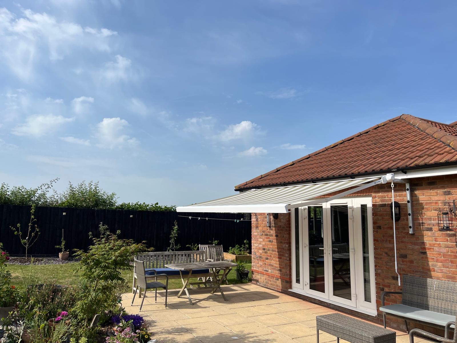 Striped awning providing shade over a garden patio