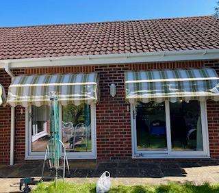 Striped canopy providing shelter above a window