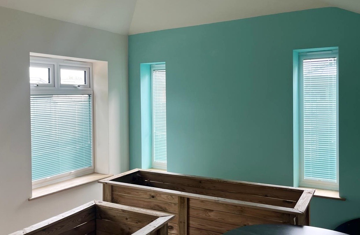Teal venetian blind fitted in a teal and white room