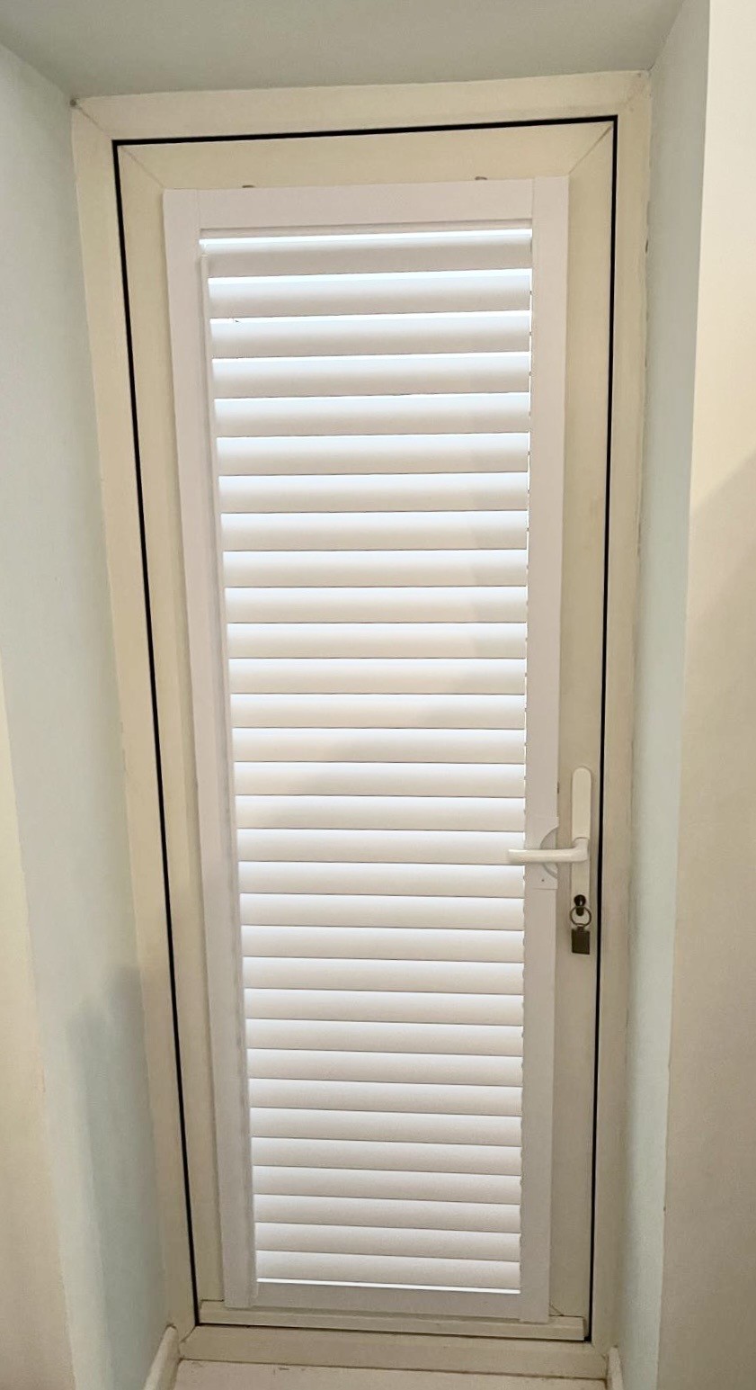 White perfect‑fit blind installed on a white uPVC door