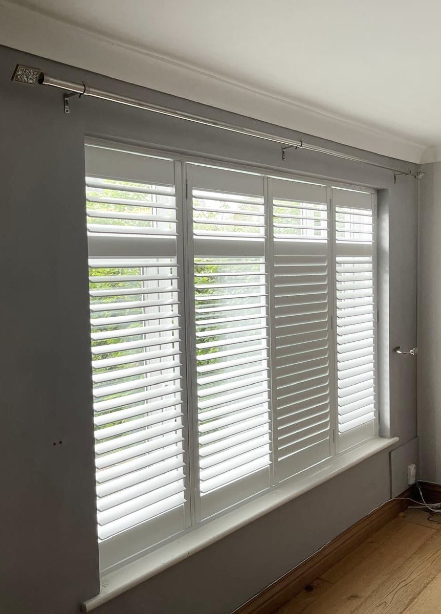 White shutters installed in a stylish grey room.
