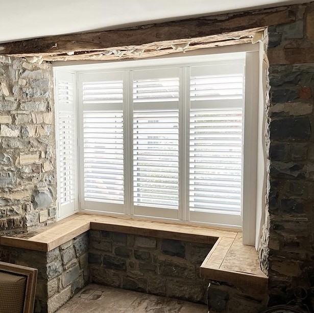 White shutters installed on a traditional sash window
