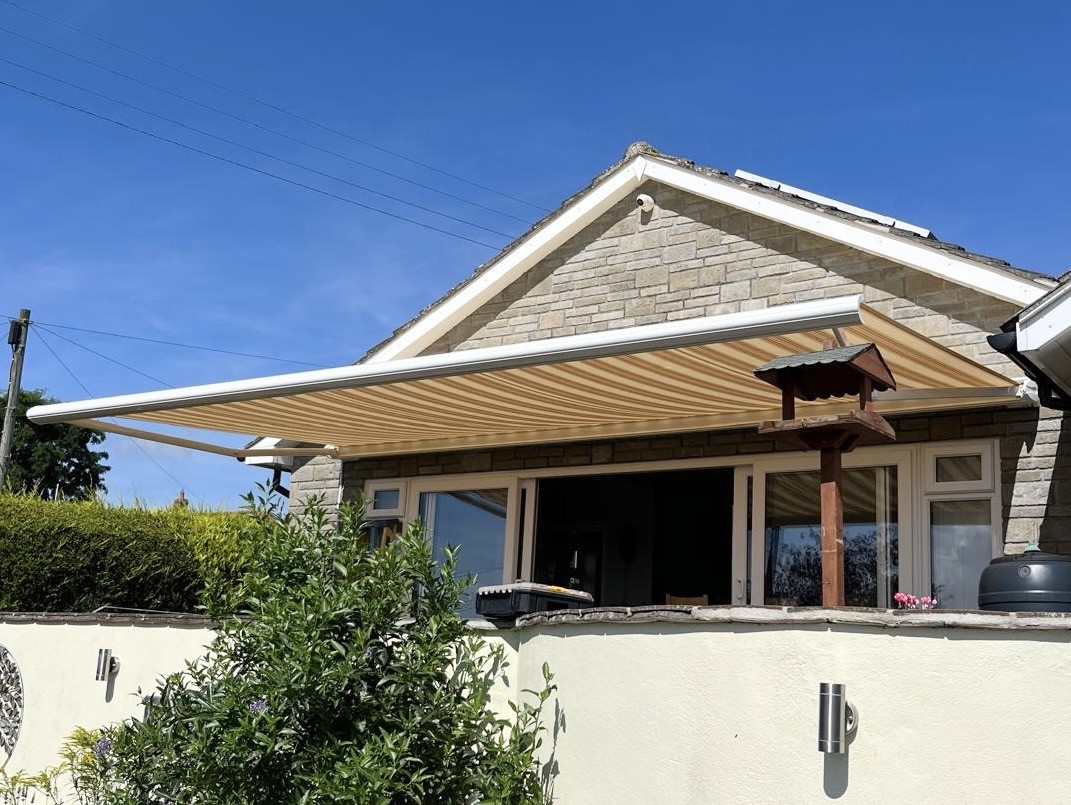 Yellow striped awning installed above outdoor seating area